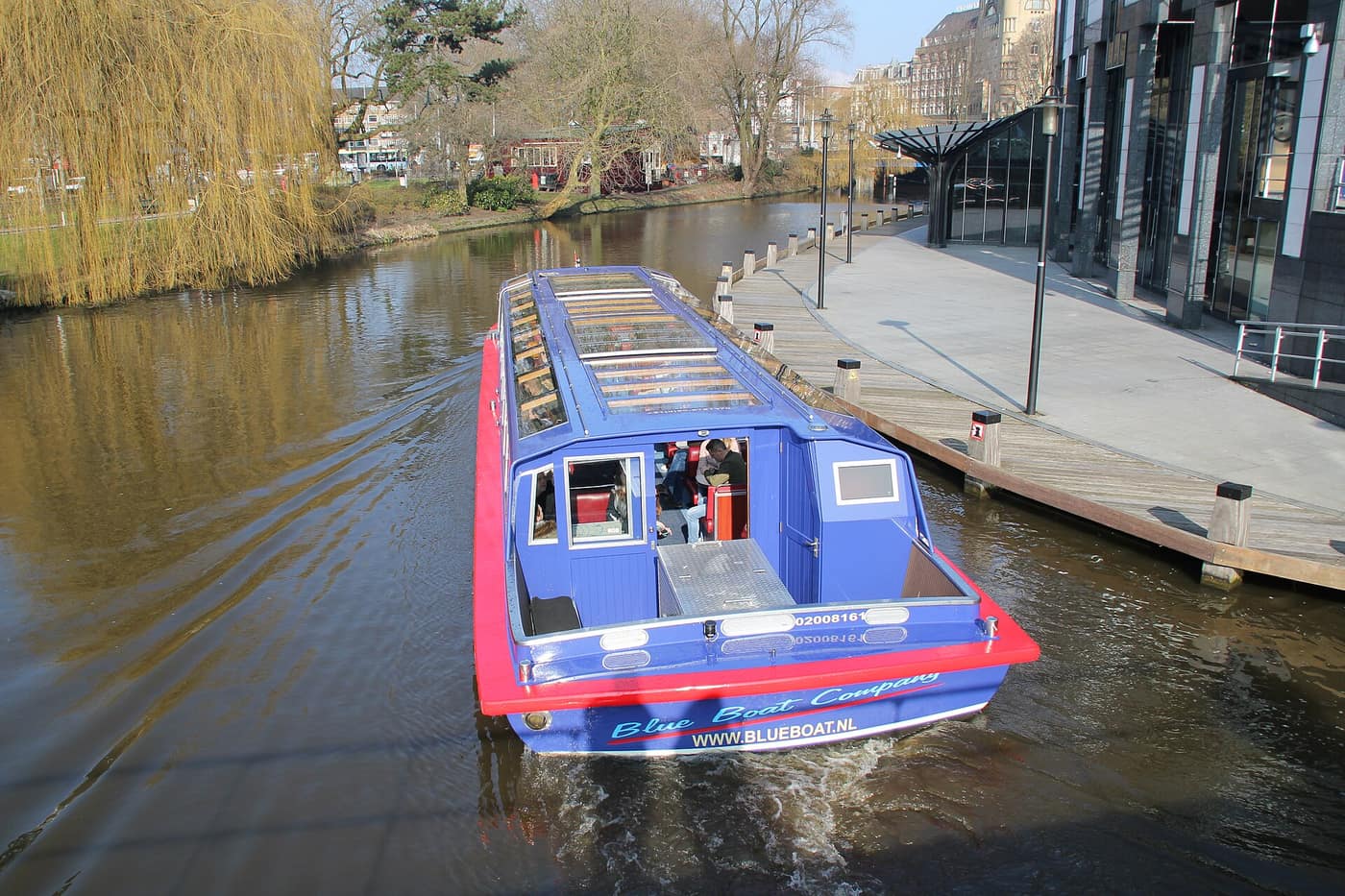A glass-roofed canal cruise boat in Amsterdam