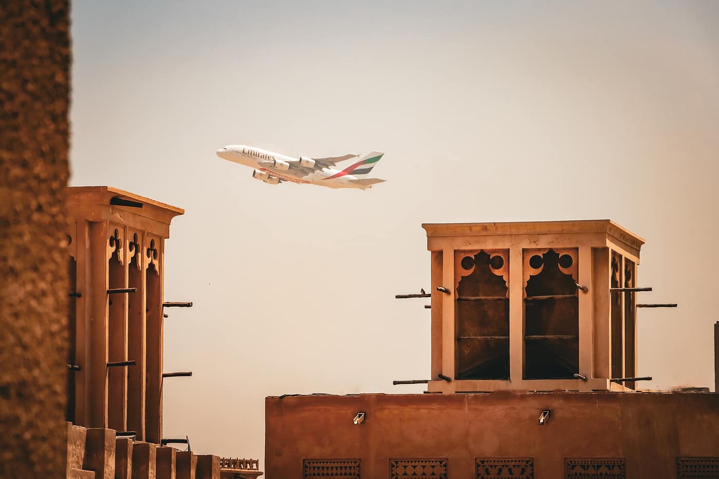 Wind towers in Al Fahidi, Dubai, with an aircraft overhead